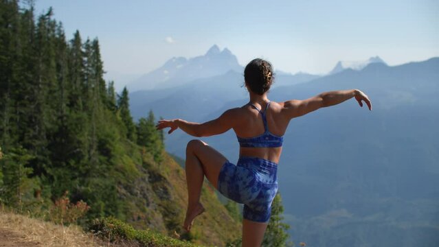 Girl doing elegant yoga pose on mountain top