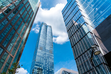 Fototapeta na wymiar Towers of skyscrapers leaving their peaks in the blue sky