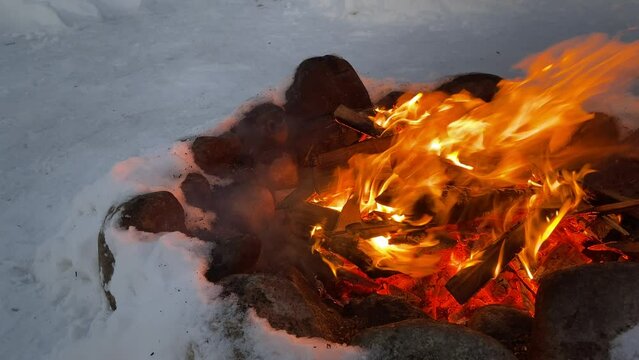 Bonfire on the street in winter. The fire is fenced with stones. The concept of tourism, travel, vacation.