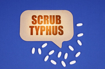 On the blue surface of the tablet and a cardboard plate with the inscription - Scrub typhus