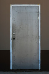 An image of a single industrial exterior door on a brown and beige building.