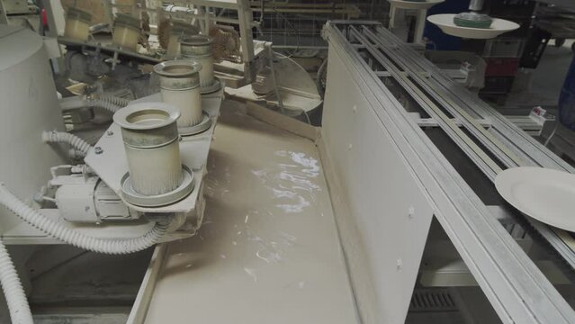 Conveyor for glazing ceramic plates. Production of porcelain workshop.