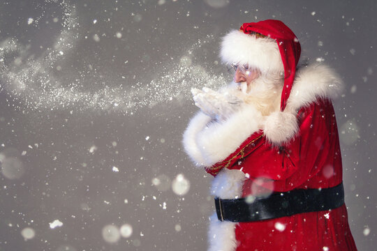 Magical photo of real Santa Claus blowing in snow. Merry Christmas and Happy New Year!