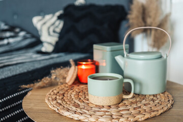 Bedroom decorative objects on the bed in cozy vintage bedroom. Two cups of tea and a ceramic teapot. Home decoration concept