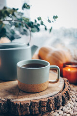 Cup and teapot in Scandinavian style on a wooden tray