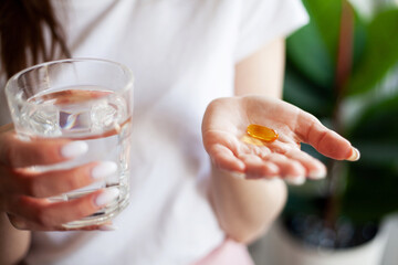 Woman doctor nutritionist hands in white t-shirt with omega 3