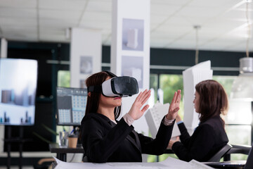 Architect in vr headset working on project in metaverse. Asian employee engineering in architecture...