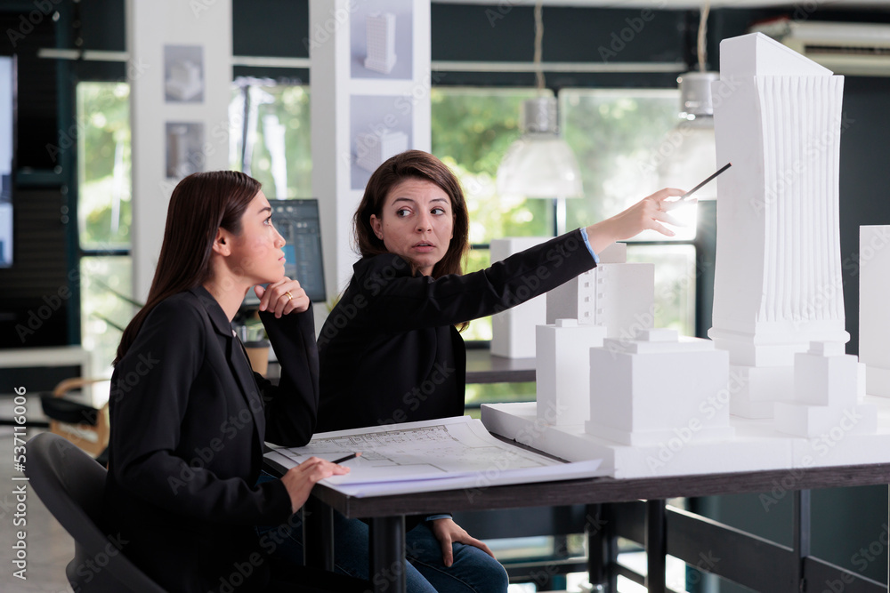 Aufkleber women working with project draft, discussing building 3d printed model in architecture office. archi