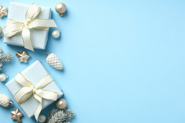 Winter holidays composition with gift boxes, baubles, stars, pine cones on pastel blue background. Christmas greeting card template. Happy New Year cover design.