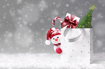 Christmas snowman with shopping bag on snow and Christmas gift. Winter Sale banner. Delivery gifts. Snowman gifting. - 537116608