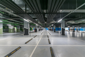 An empty underground parking lot of a shopping center or the interior of a garage with concrete columns.