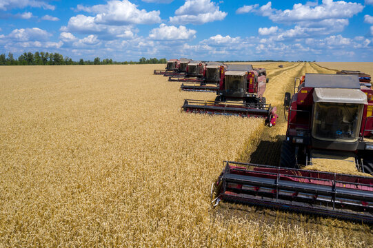 The battle for the harvest, harvesters and other agricultural machinery lined up in a diagonal for harvesting wheat view from the top with a quadcopter