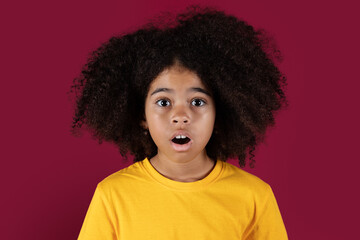 Portrait of shocked black girl on colorful background