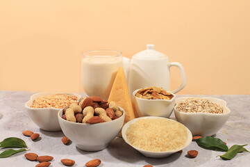 Assortment of vegan non-dairy products on a concrete table, shop banner, plant-based alternative dairy products - milk, cream, yogurt, cheese, nuts, rice, oatmeal, lentils, healthy natural food 
