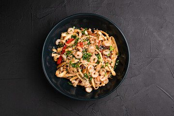 Wok, wok noodles with different fillings on a black background