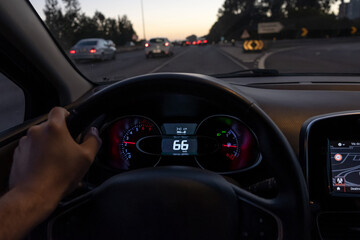 Driver view to the speedometer at 66 kmh or 66 mph on a high traffic road, night fall view from...
