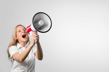 Young woman holding and screaming in a megaphone