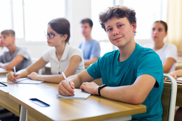 Fototapeta premium Education, learning and people concept - group of students at school lesson