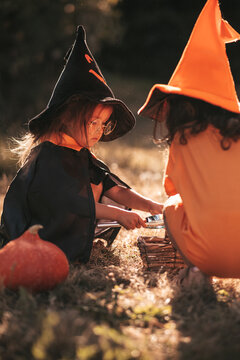 two little girls celebrate Halloween in nature pumpkin