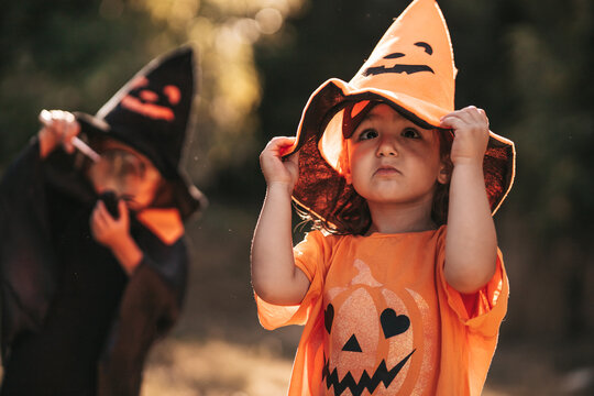 two little girls celebrate Halloween in nature pumpkin