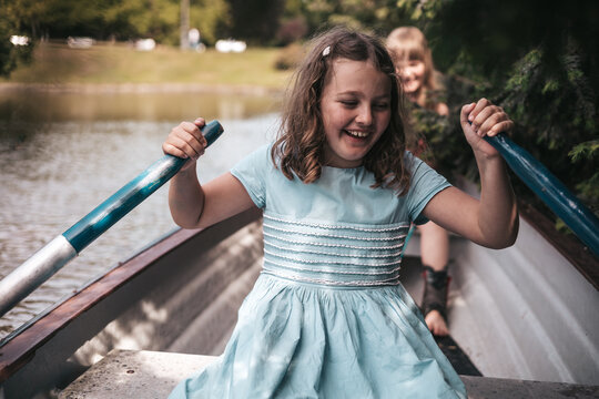 girl on a boat rowing oars,  vacation  in the village