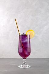 Lavender iced cocktail. Purple refreshing drink. Herbal ice tea or natural lemonade in tall...