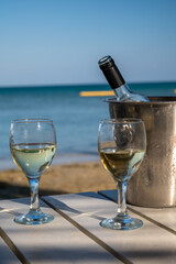 Drinking of cold white wine in beach bar, summer holidays, relax on sandy beach