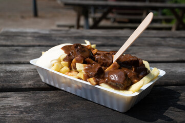 Traditional street food in Belgium, French fried potatoes with beef stew and mayonnaise