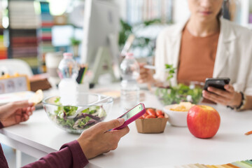 People having lunch break and using their smartphones