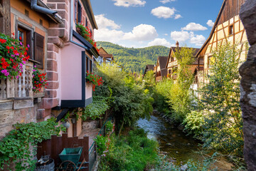 Fototapeta na wymiar Half timbered medieval homes line the Weiss river canal in the historic town center of Kaysersberg, France in the Alsace region. 