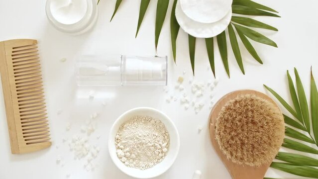 Natural cosmetics, skin care products. Bottle with pipette with gel, fluid, collagen serum, oil, cream, lotion, massage stone on a white background with palm leaves. Organic cosmetics. flat lay. 4k