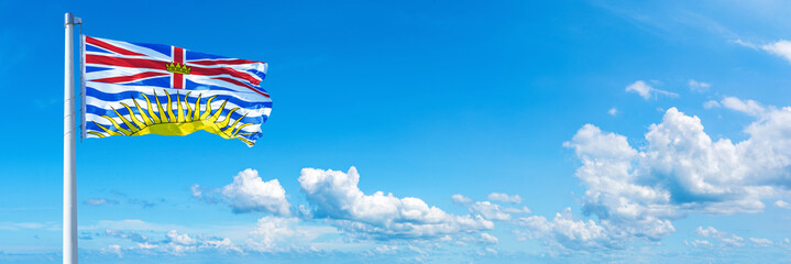 British Columbia - Canada flag waving on a blue sky in beautiful clouds - Horizontal banner
