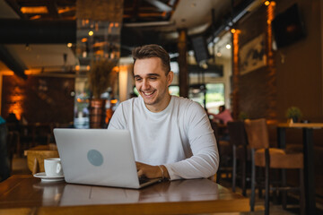 One man young adult caucasian male working on laptop computer at cafe
