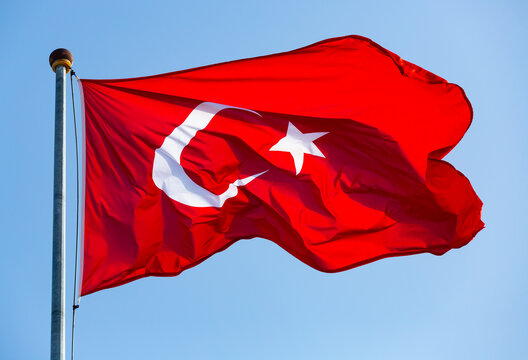 Turkish flag hang on a pole, blue sky on background