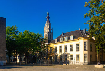 Fototapeta na wymiar Streets of Breda, view of Grote Kerk tower (Onze-Lieve-Vrouwekerk) over deep blue sky.
