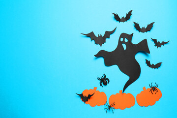 Flat lay composition with paper ghost, bats and pumpkins on light blue background, space for text. Halloween celebration