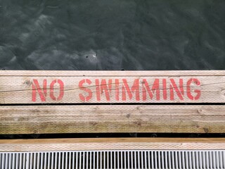 No swimming sign by the wooden deck