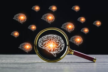 Magnifier glass with symbol neurons in the brain. Concept of idea and innovation, on wooden table.