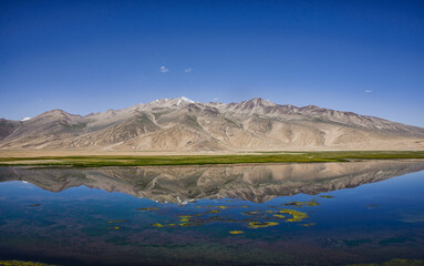 Fototapeta na wymiar Reflecting rainbow mountains on Lake Bulunkul, Pamir Highway, Tajikistan