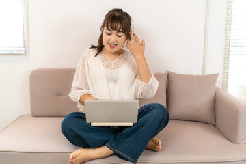 Fototapeta premium 自宅でノートパソコンを操作する若い女性