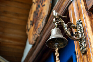 ancient bronze bell placed next to a door
