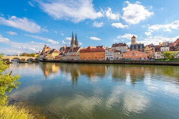 The picturesque skyline including the stone bridge over the Danube River, Saint Peter's Church and Regensburg Town Hall in the Bavarian city of Regensburg, Germany. - obrazy, fototapety, plakaty