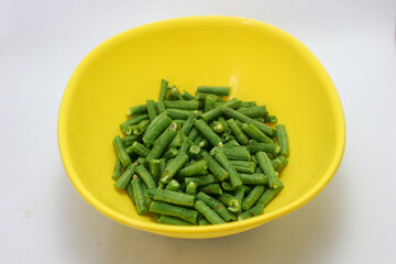 chopped long beans and put in a yellow bowl.Fresh yard long bean have sweet taste and crisp, high nutrition and vitamins. Food and vegetable concept.