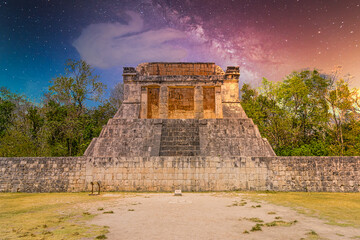 Obraz na płótnie Canvas Temple of the Bearded Man at the end of Great Ball Court for playing pok-ta-pok near Chichen Itza pyramid, Yucatan, Mexico. Mayan civilization temple ruins with Milky Way Galaxy stars night sky
