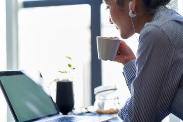 mature asian woman working from home using notebook computer