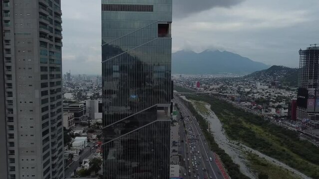 big building with mirror with a cerro behind in a cloudy day