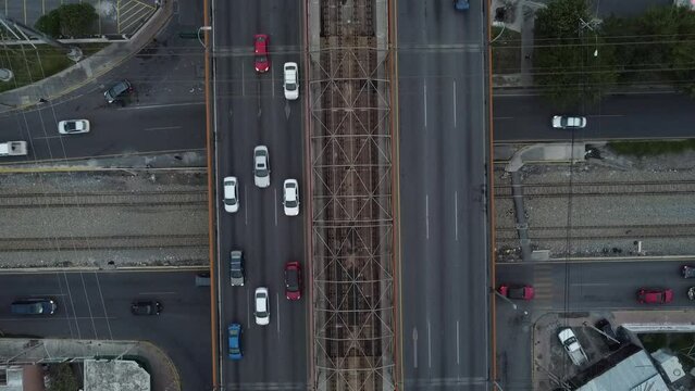 aerial train going around and below cars and train rails
