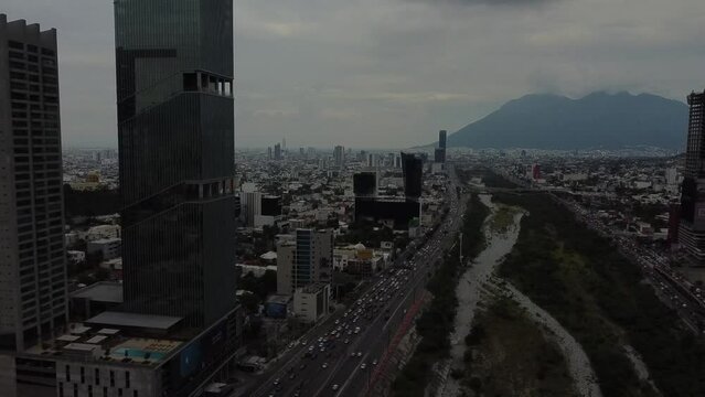 building with lots of mirrors with a cerro behind it in a cloudy day