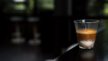 Dirty Coffee - A glass of espresso shot mixed with cold fresh milk in coffee shop cafe and restaurant