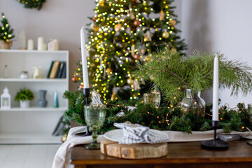 A festive Christmas table set with fir branches and lights